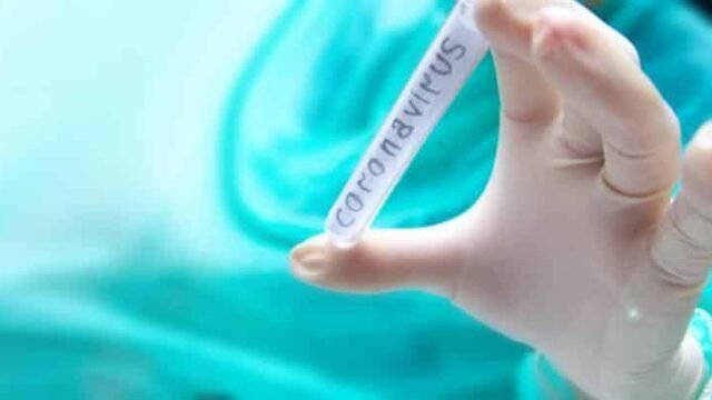 Ръка в медицинска ръкавица държи епруветка с надпис coronavirus
