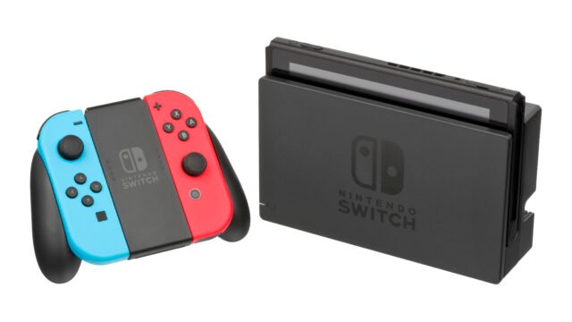 Конзолата Nintendo Switch в док станция до контролерите Joy-Con, поставени в държач