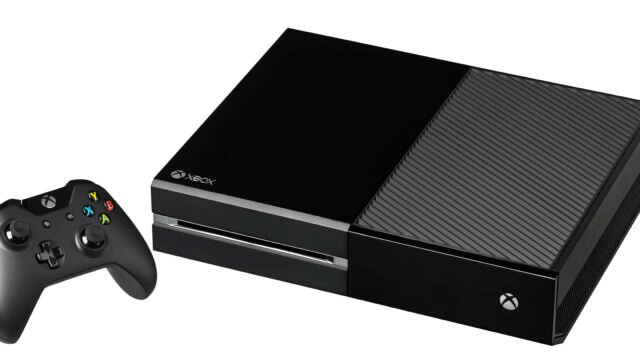 Черна конзола Xbox One с безжичен контролер до нея на бял фон