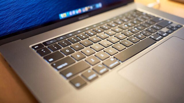 Отворен MacBook Pro 16 инча от 2019 г. с клавиатура и Touch Bar, на екрана се вижда докът на macOS
