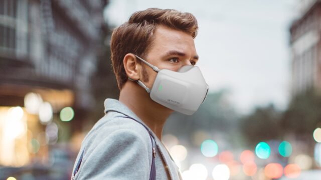 Мъж на улицата с носимия пречиствател на въздух LG PuriCare на лицето