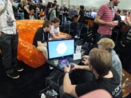 Посетители играят инди игри на изложение