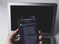Смартфон с чат в ChatGPT пред лаптоп – заключени чатове в ChatGPT
