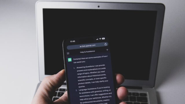 Смартфон с чат в ChatGPT пред лаптоп – заключени чатове в ChatGPT