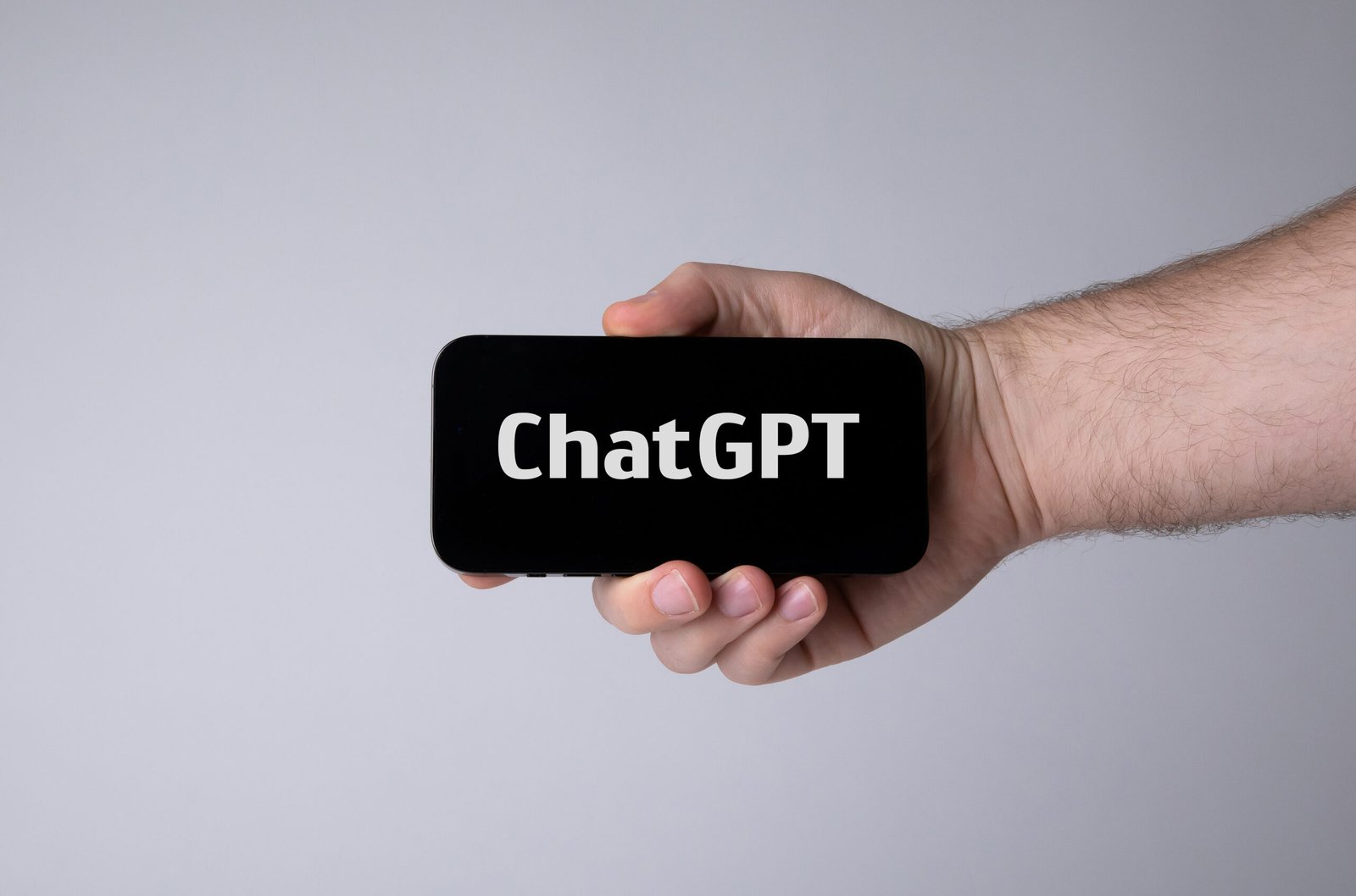 Ръка държи смартфон с надпис ChatGPT на екрана