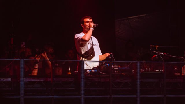 Британският продуцент Fred again.. пее с микрофон зад DJ пулт на концерт в Лондон