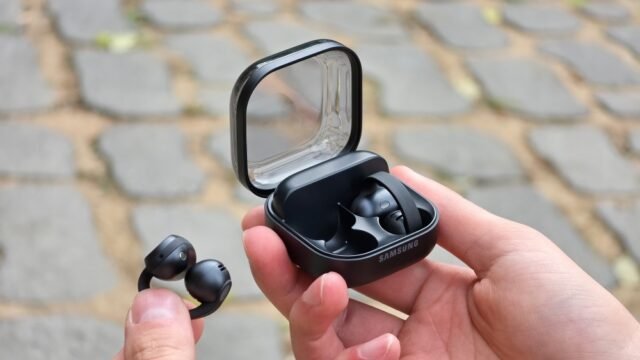 Отворените слушалки Galaxy Buds On с клипс и кутията им за зареждане в ръка