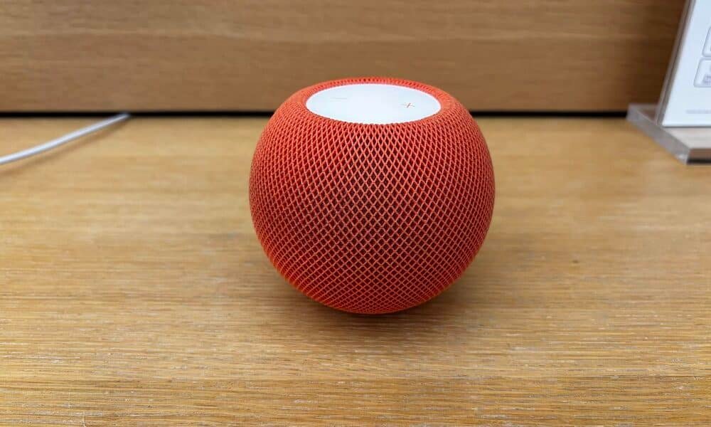Оранжев HomePod mini върху дървена повърхност