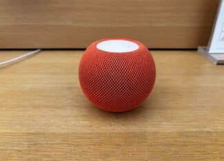 Оранжев HomePod mini върху дървена повърхност