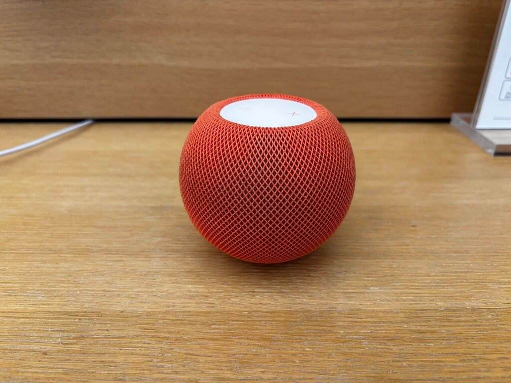 Оранжев HomePod mini на дървен рафт – колона, която работи и като Thread гранична точка