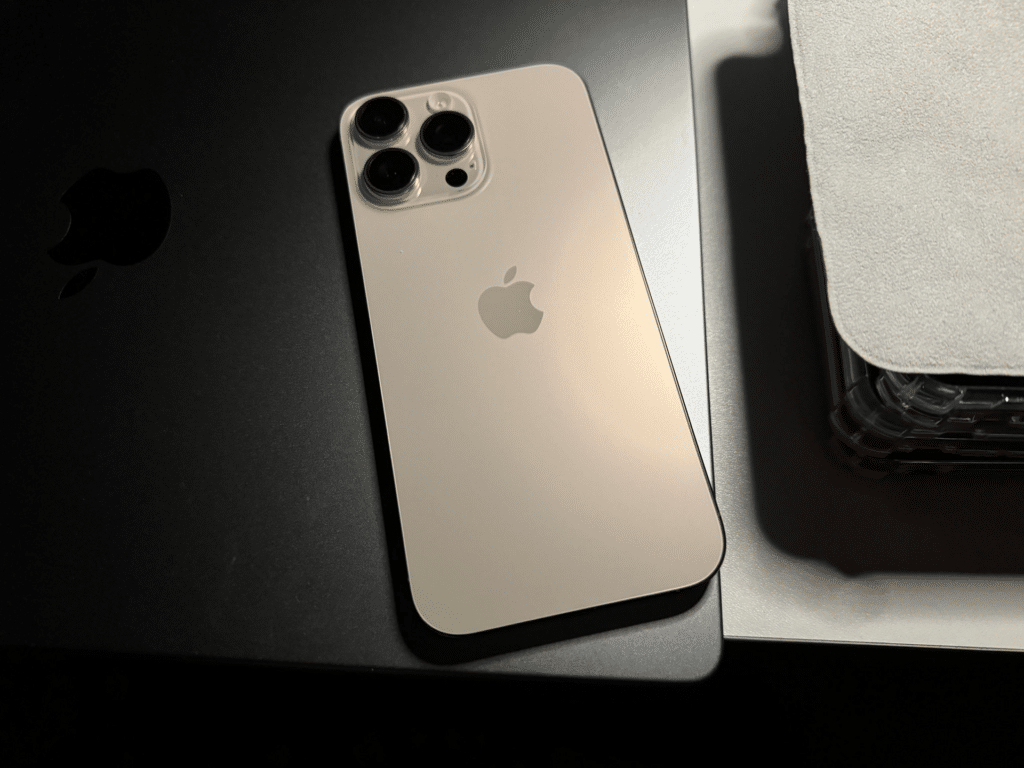 Гърбът на iPhone 16 Pro Max в цвят Desert Titanium с трите камери