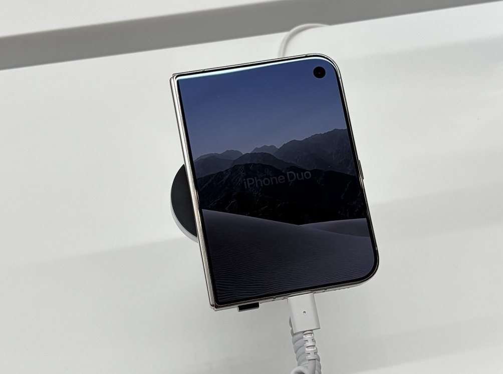 Сгънат iPhone Duo с включен външен екран на демонстрационна стойка в магазин в България
