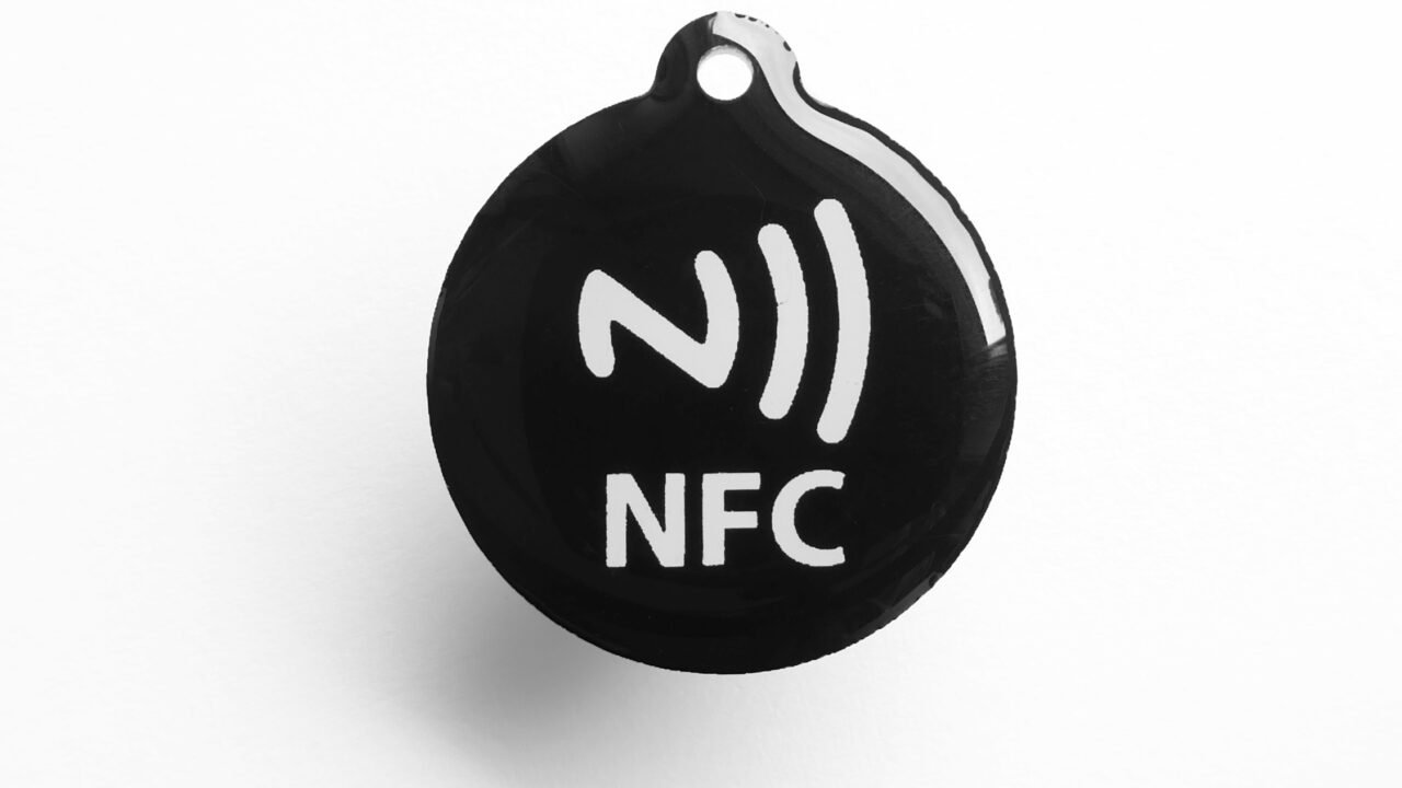 Черен NFC таг с бял символ за безконтактна връзка – с такива тагове се пускат автоматизации в умния дом