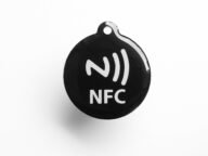 Черен NFC таг с бял символ за безконтактна връзка – с такива тагове се пускат автоматизации в умния дом