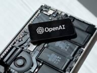 Телефон с логото на OpenAI върху разглобен лаптоп – OpenAI модели в Google Cloud