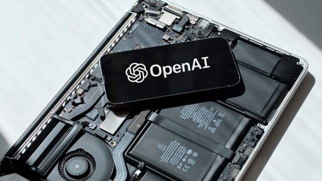 Телефон с логото на OpenAI върху разглобен лаптоп – OpenAI модели в Google Cloud
