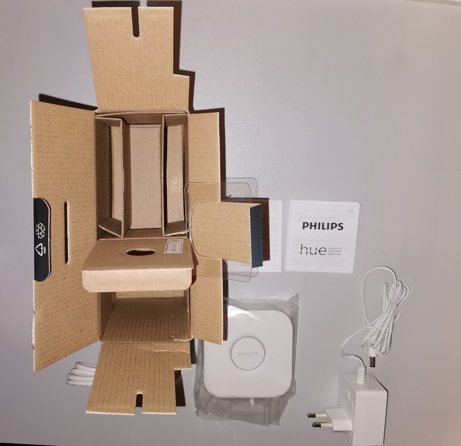 Philips Hue Bridge, извадена от кутията, със захранващ адаптер