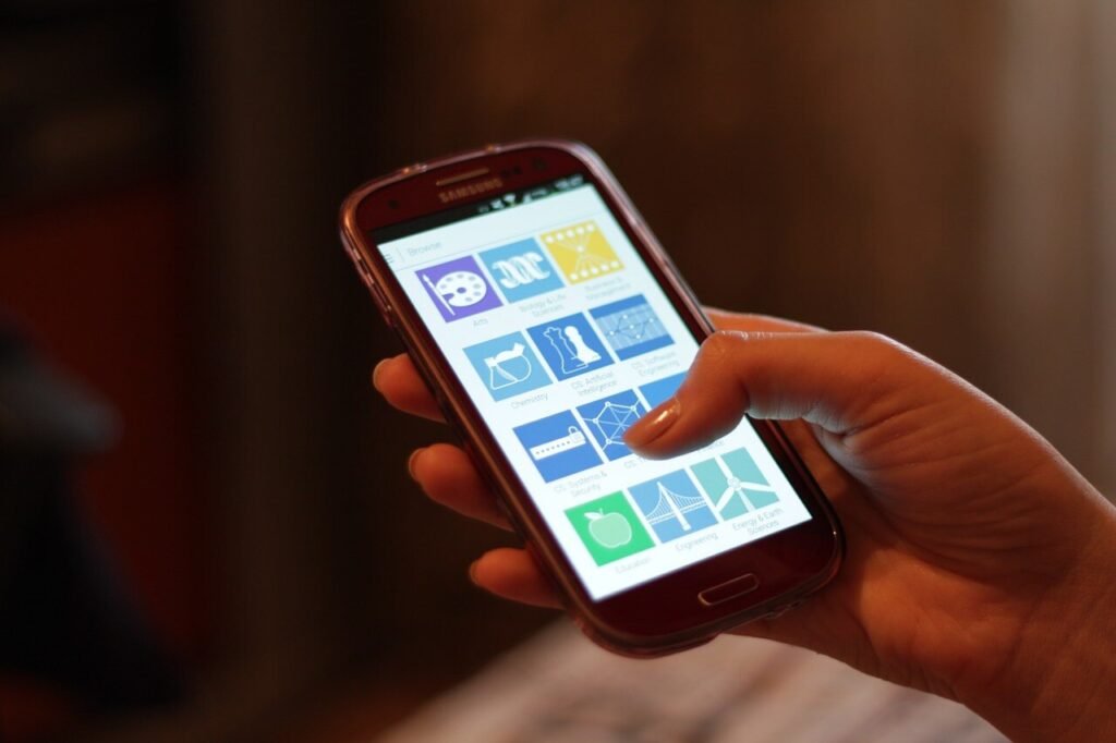 Ръка държи смартфон с Android и отворен екран с приложения