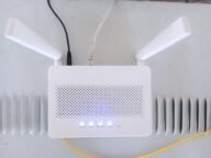 Бял домашен Wi-Fi рутер със светещи индикатори – смяната му засяга устройствата в умния дом