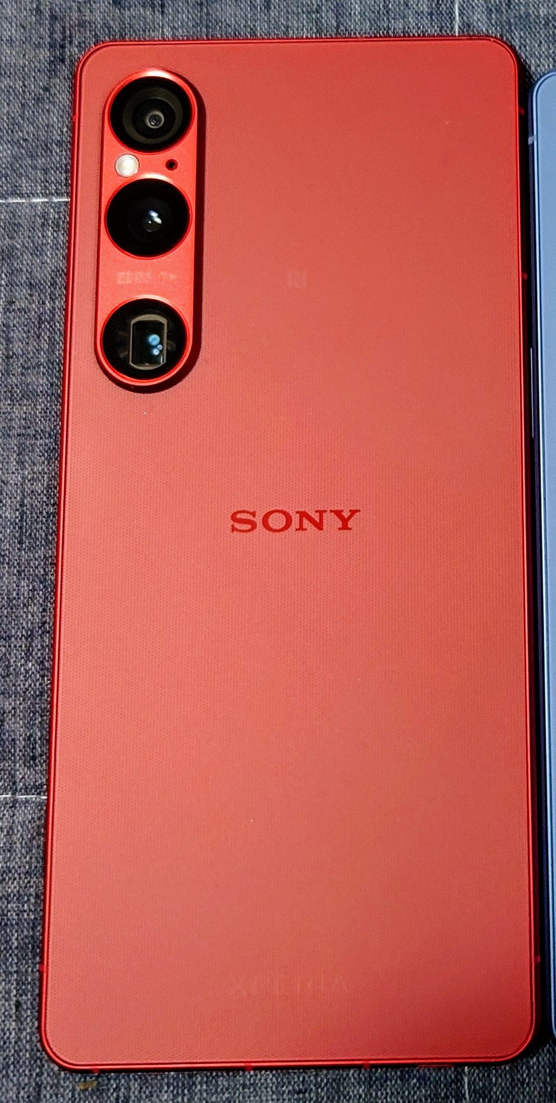 Гърбът на червен смартфон Sony Xperia 1 VI с вертикален модул от три камери