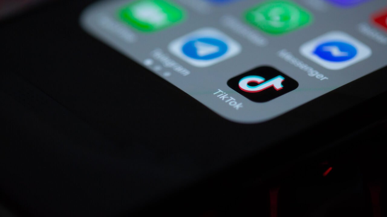 Иконата на TikTok сред други приложения на екрана на смартфон – тема: документи за детска безопасност в TikTok