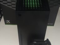 Конзола Xbox Series X с контролер пред кутията си – основата на Xbox Series X25