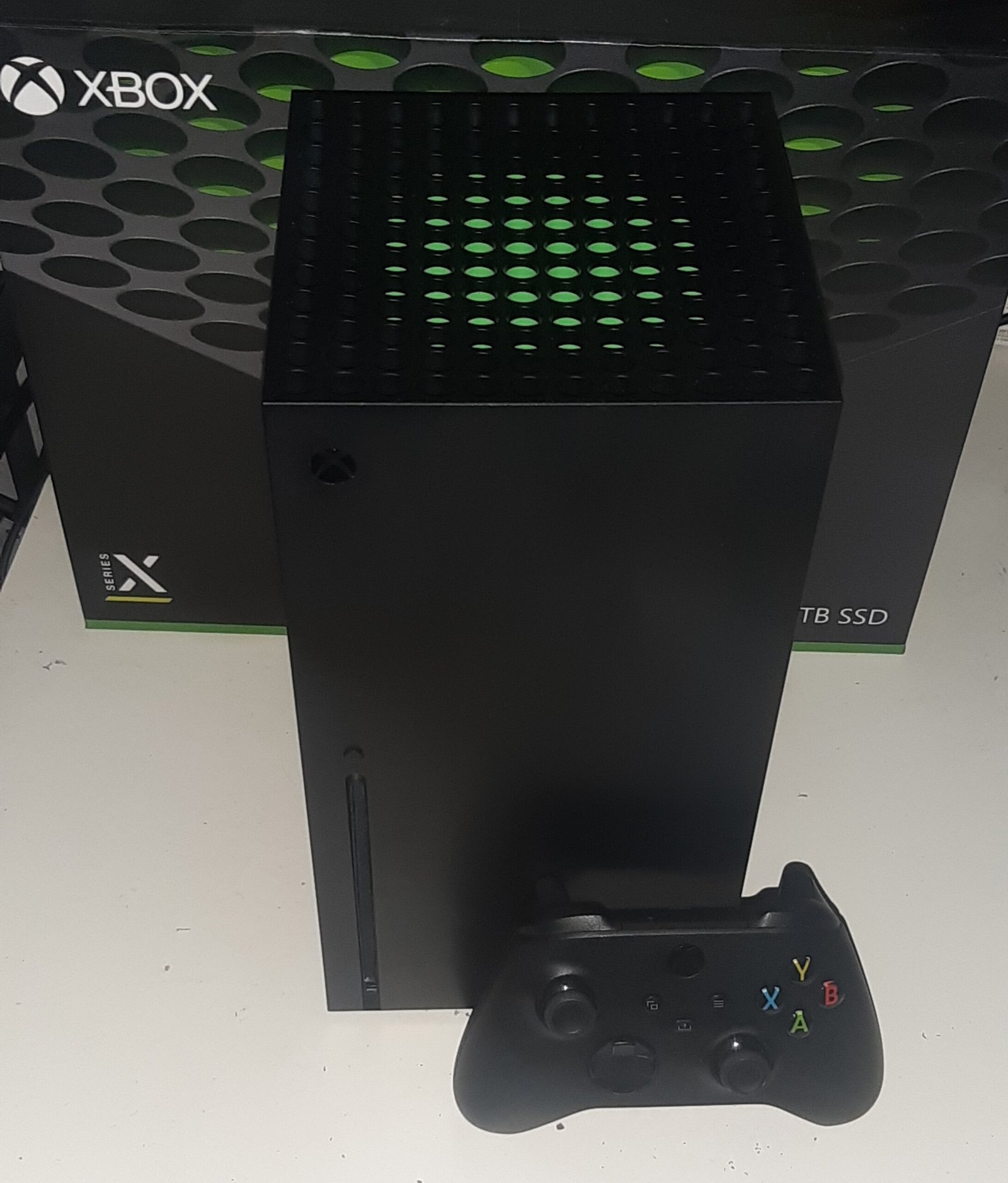 Конзола Xbox Series X с контролер пред кутията си – основата на Xbox Series X25
