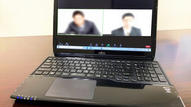 Лаптоп с видеоразговор в Zoom, в който лицата на участниците са замъглени